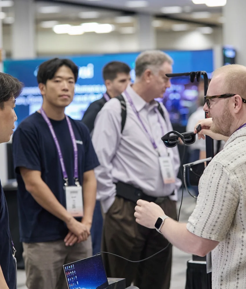 Enterprise attendees in an active technical conversation on the expo floor